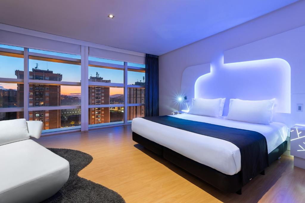 1 dormitorio con cama extragrande y sofá en Eurostars Palacio de Cristal en Oviedo