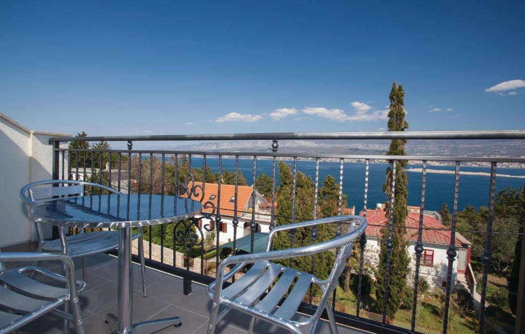 einen Balkon mit einem Tisch und Stühlen sowie Blick auf das Wasser in der Unterkunft Villa Janja in Šilo