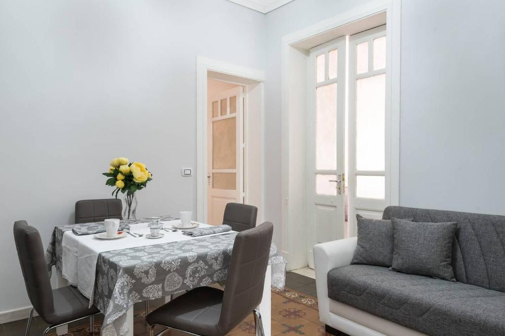 a dining room with a table and a couch at Gramignani House Catania in Catania