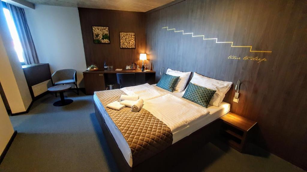 a bedroom with a large bed with a wooden wall at Hotel D1 in Ostrovačice