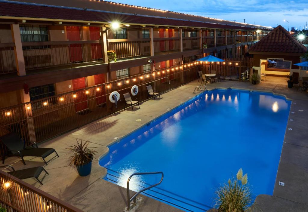 a pool on the roof of a hotel at night at San Mateo Inn in Albuquerque