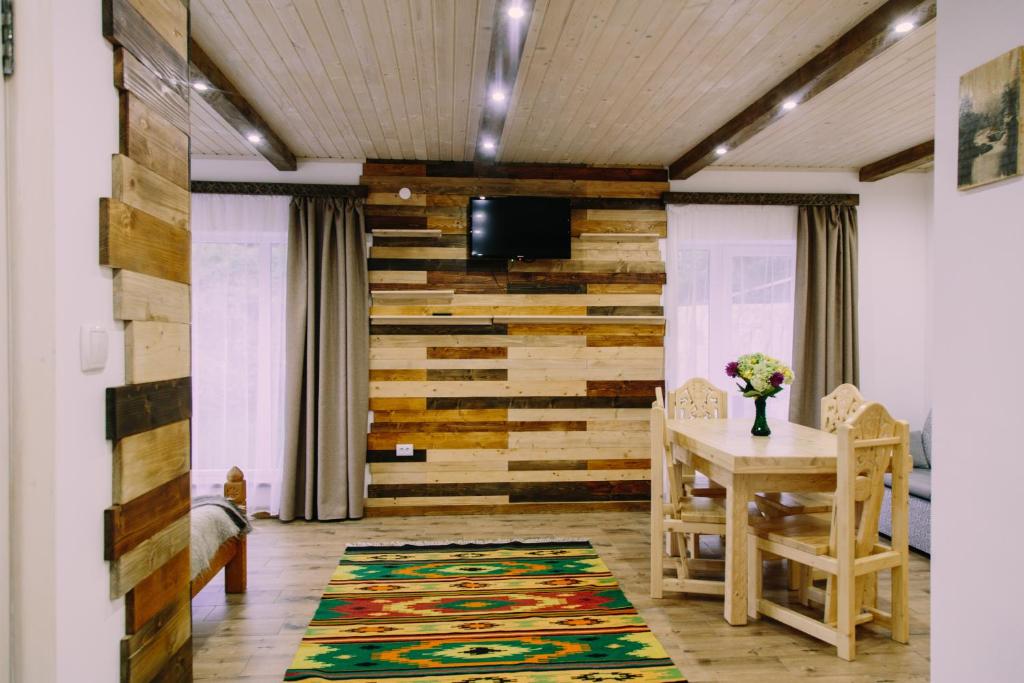 a dining room with a table and a wall of wood at Котедж "Солард" in Yaremche