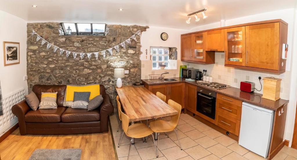 uma cozinha com um sofá e uma mesa numa cozinha em Eithin Bach em Caernarfon