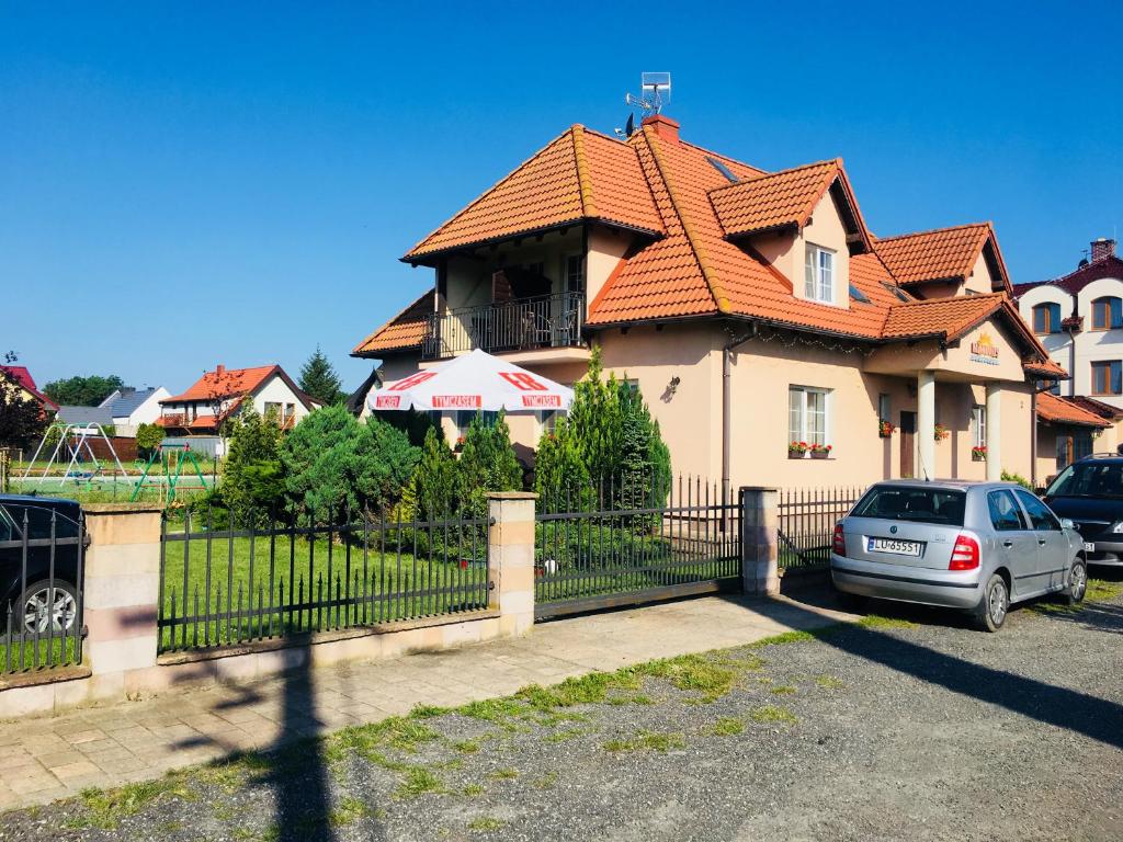 a house with an orange roof and a fence at Maximus in Krynica Morska