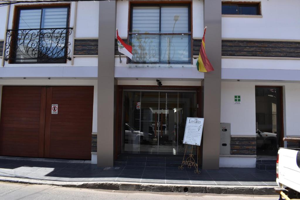a facade of a building with two doors and two flags at Hotel Boutique Vendimia in Tarija
