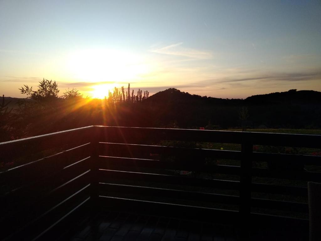 einen Sonnenuntergang über einem Zaun mit der Sonne am Himmel in der Unterkunft Sunrise Home in Maribor