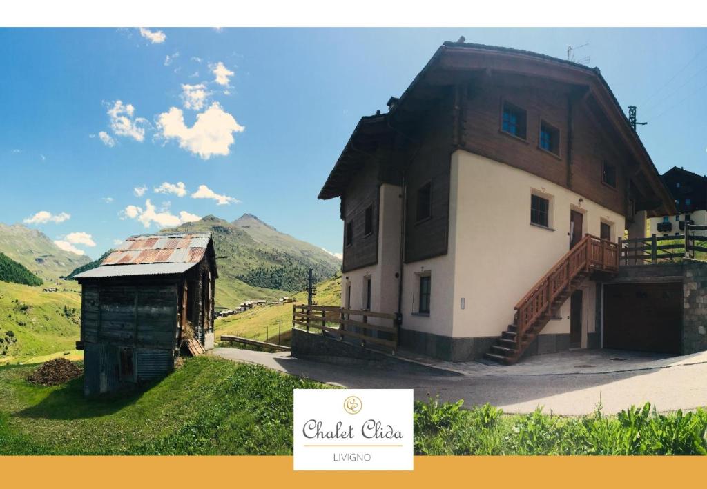 een huis met een schuur en een bord ervoor bij Chalet Clida in Livigno