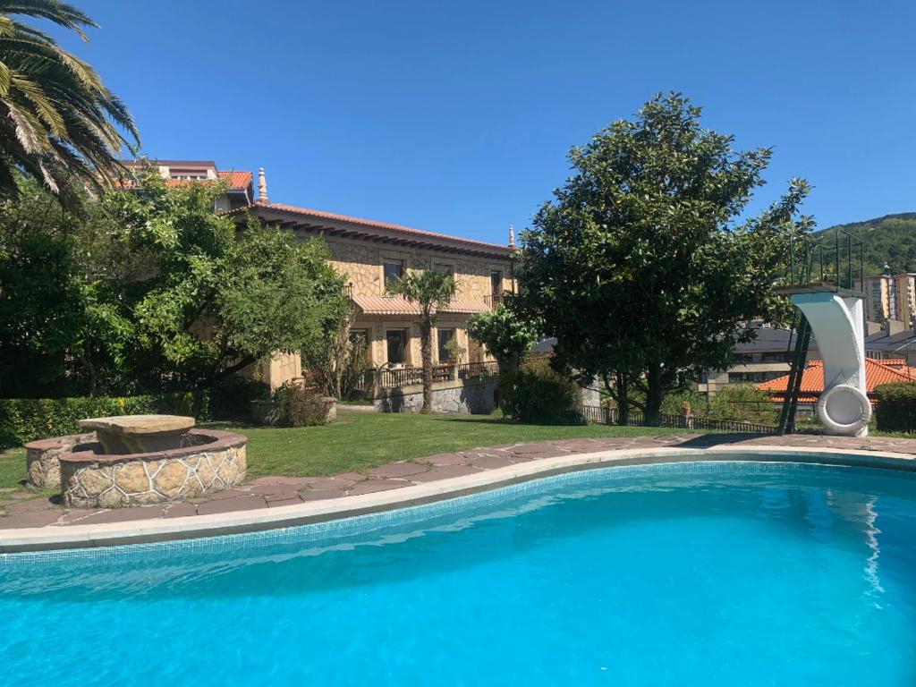 una gran piscina azul frente a una casa en Casa señorial a 5 minutos del centro, en San Sebastián