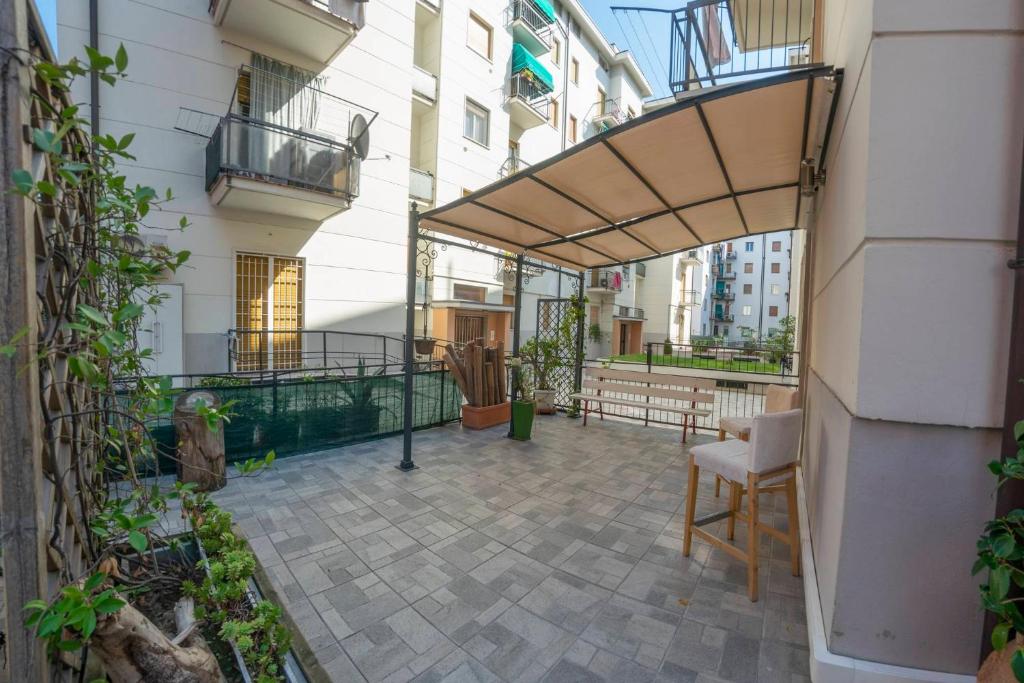 un patio esterno con tenda da sole, tavolo e sedie di Minimal Chic a Verona