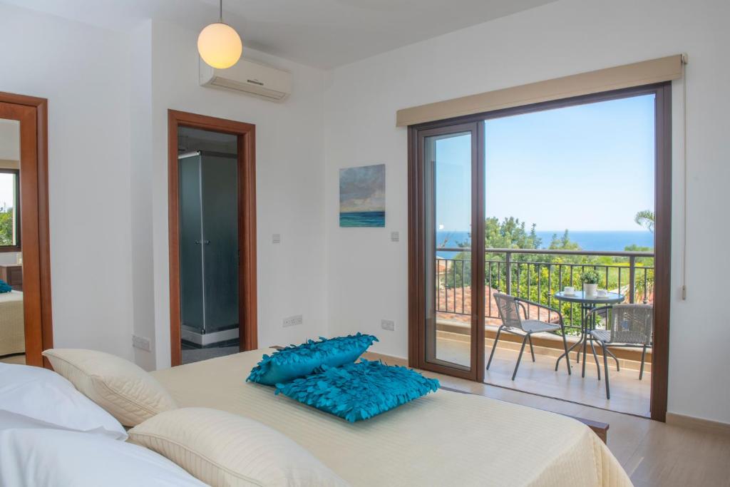 a bedroom with a bed and a balcony with a view at Kallizoni villa in Paphos City