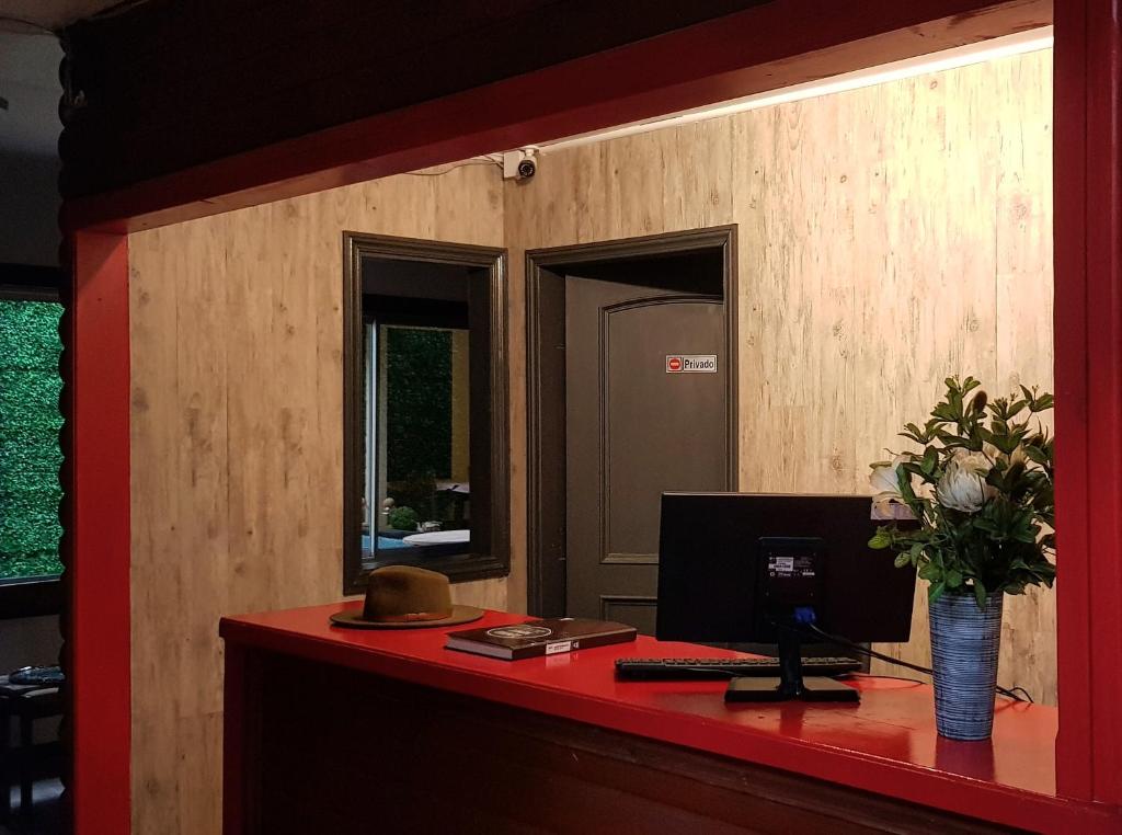 ein Büro mit einem roten Schreibtisch mit einem Computer darauf in der Unterkunft Hostal Centro Montt in Temuco