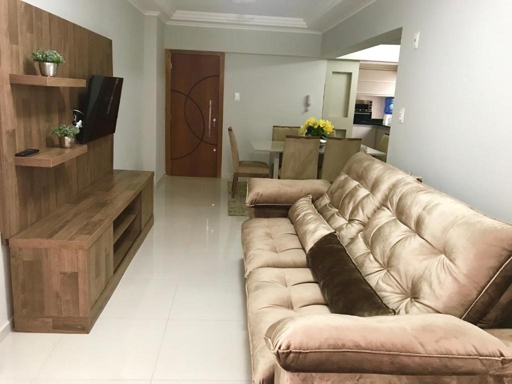 - un salon avec un grand canapé et une télévision dans l'établissement MARAVILHOSO apartamento QUADRA MAR em BC, à Balneário Camboriú