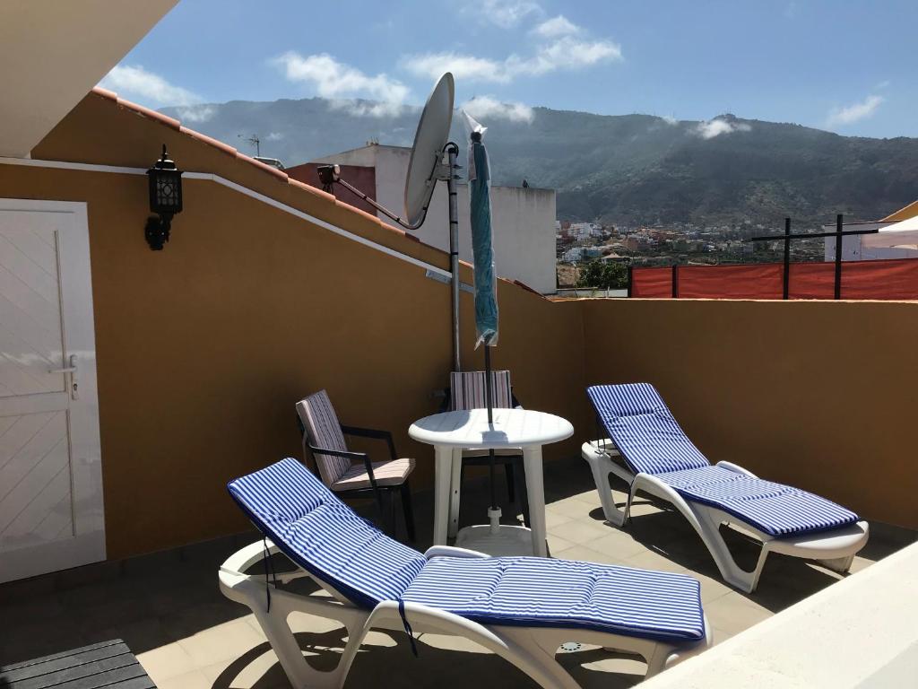 a patio with chairs and a table on a roof at Teleworking Silent new and modern in Los Realejos