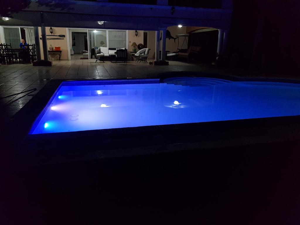 una piscina azul en una habitación oscura en Metro Country Club en Juan Dolio