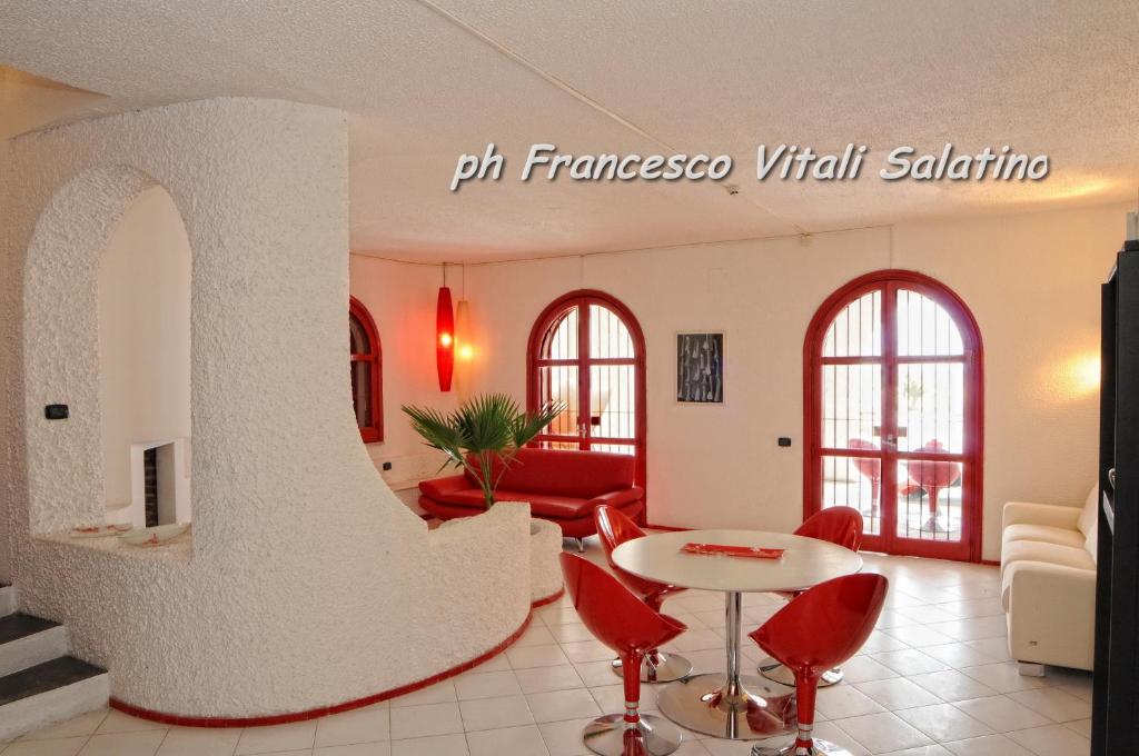 a living room with red chairs and a table at Villa Lulu in Schiavonea