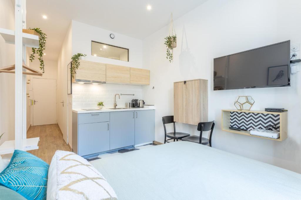 eine Küche und ein Wohnzimmer mit einem Waschbecken in der Unterkunft Le Cocon Villette in Lyon