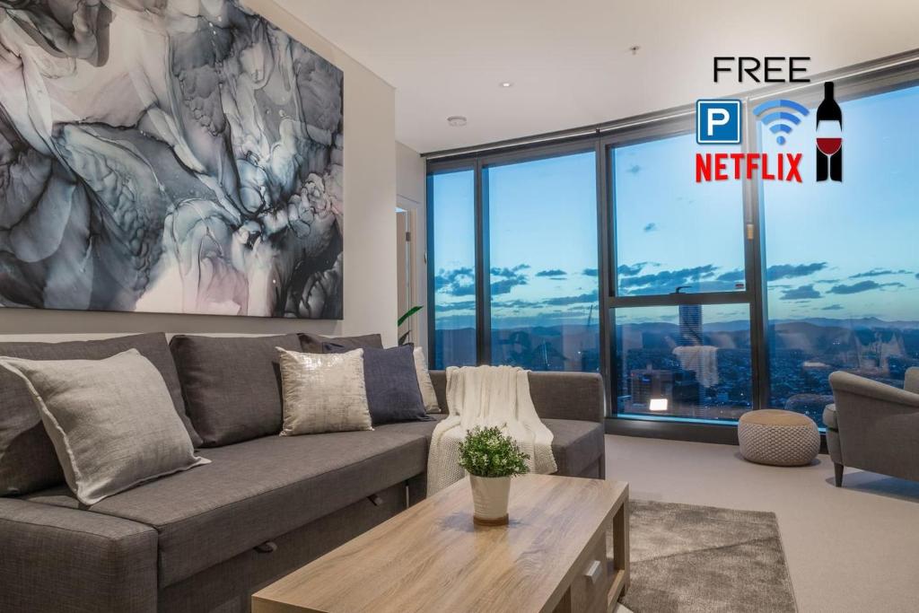 a living room with a couch and a large window at Highlife Luxury*Carpark*Wifi*Pool*Gym*Netflix in Brisbane