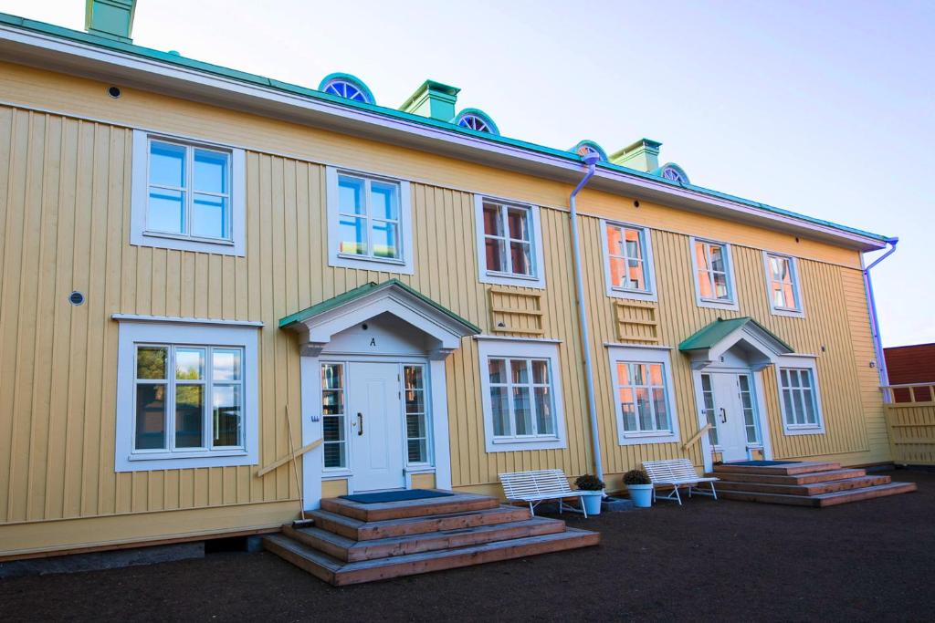 a large yellow building with benches in front of it at Upseeritalo in Seinäjoki