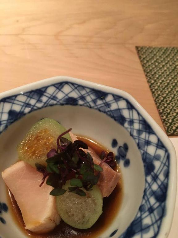 una ciotola di cibo con carne e sottaceti su un tavolo di 小さなお宿 乃むら a Kanazawa