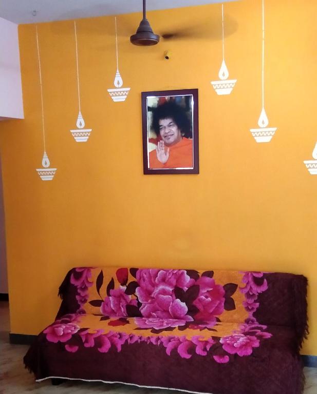 ein Schlafzimmer mit einem Bett mit rosa Blumen drauf in der Unterkunft Atreyaa Homestay in Tiruchchirāppalli