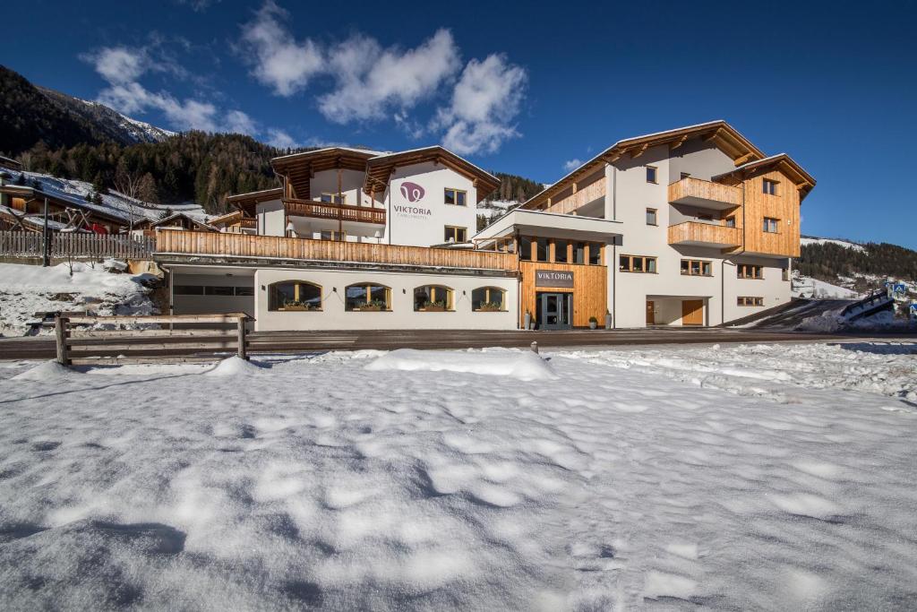 ein großes Gebäude mit viel Schnee davor in der Unterkunft Familienhotel Viktoria in Ulten