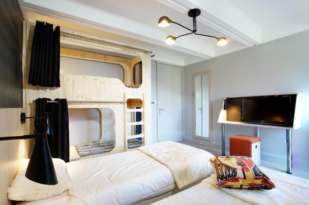 a bedroom with a large bed and a tv at Hôtel Club mmv Le Flaine *** in Flaine