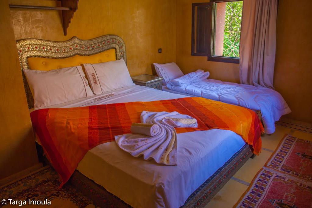 a bedroom with two beds with towels on them at Targa Imoula in Imlil