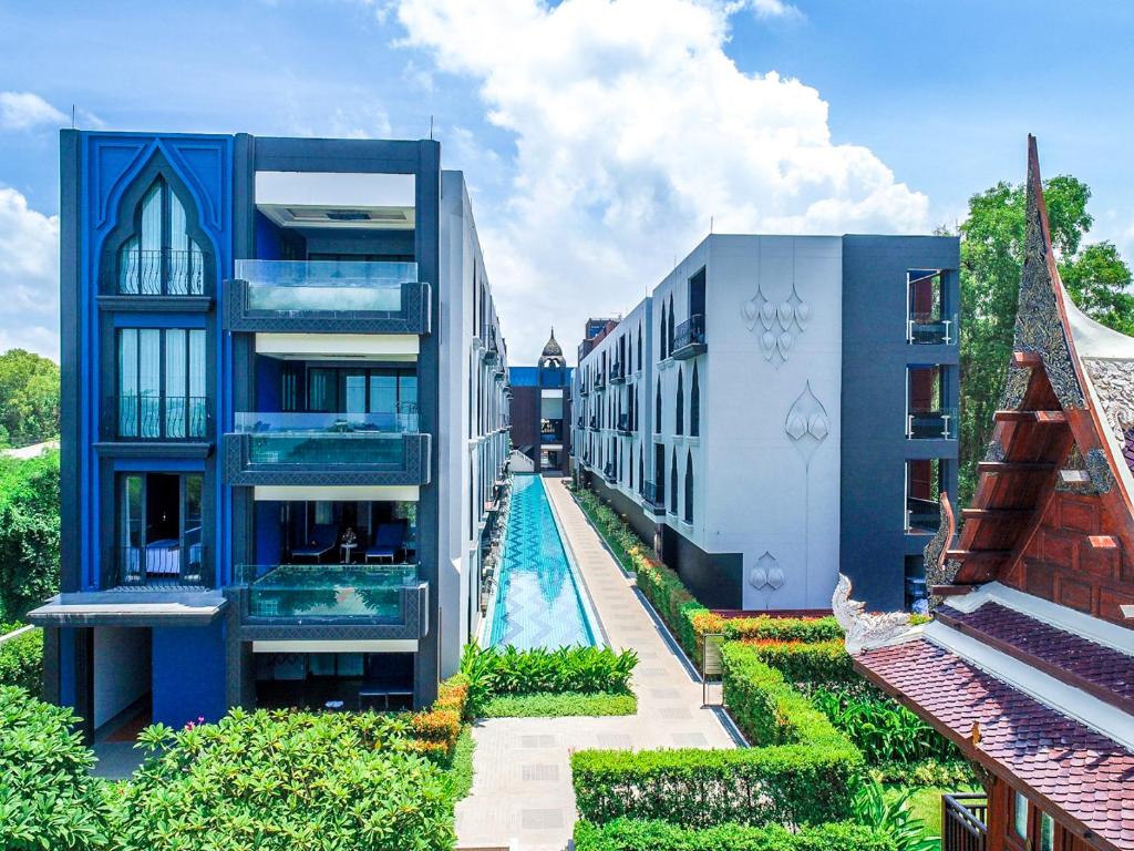 a building with a swimming pool next to a building at Aksorn Rayong, The Vitality Collection - SHA PLUS in Klaeng