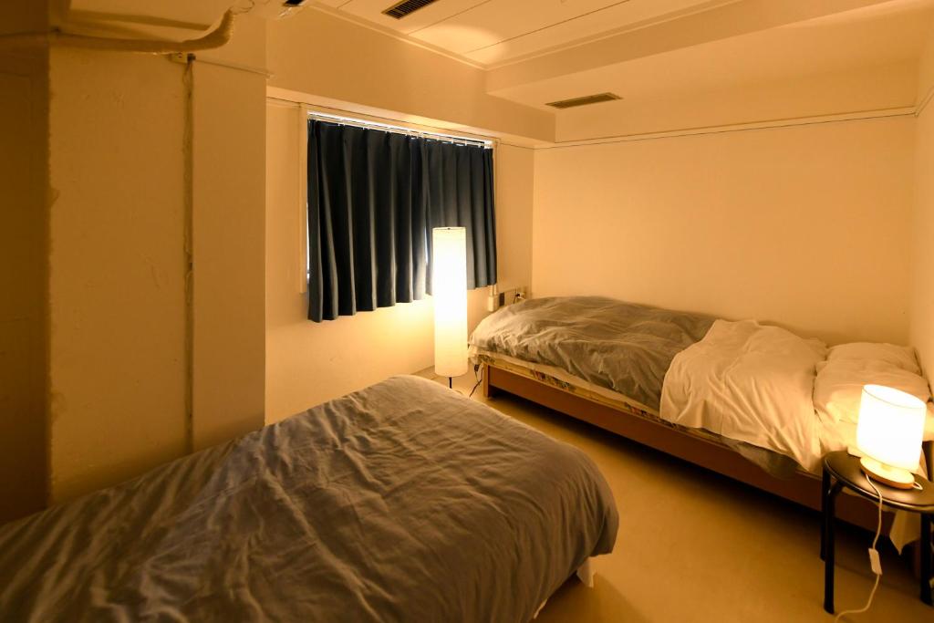 Postel nebo postele na pokoji v ubytování Guest House M104 Kagoshima