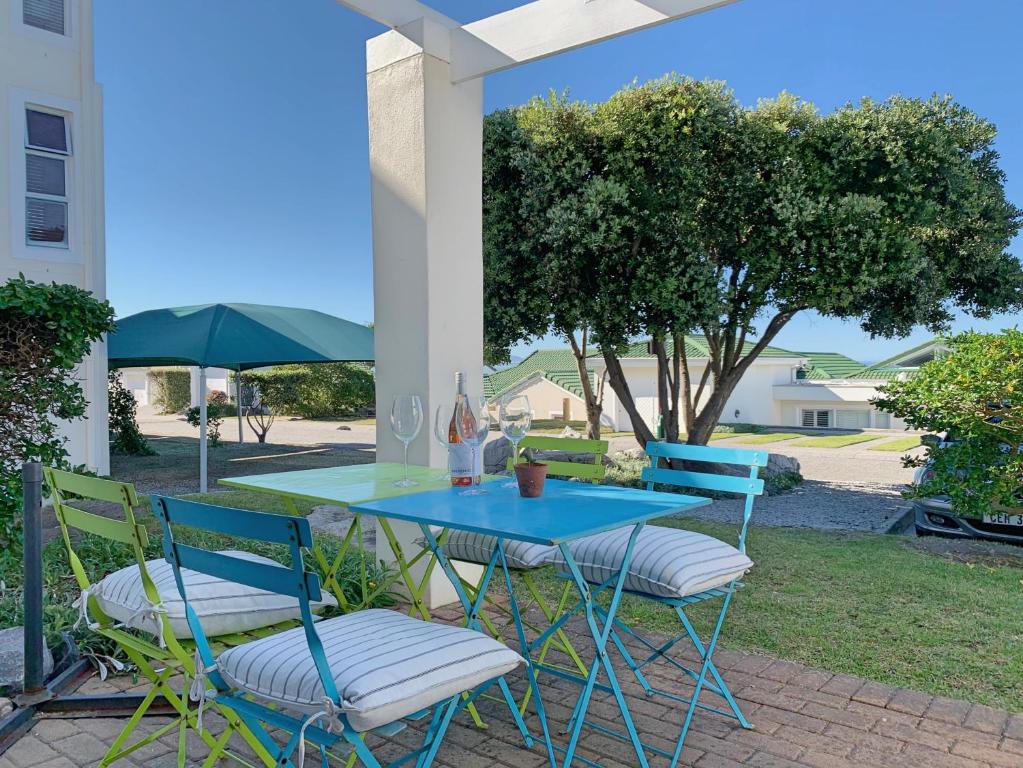einen blauen Tisch und Stühle auf einer Terrasse in der Unterkunft 63 Whalerock Estate in Hermanus