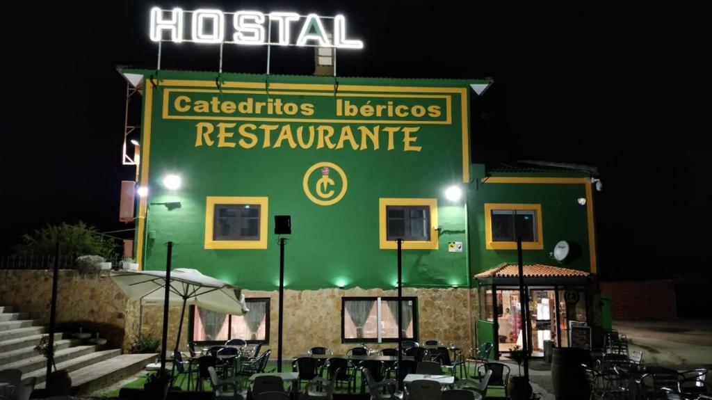 a green building with a sign that reads hospitalarios lettuceresresresres restaurant at Hostal Catedritos Ibéricos A-5 Km 154 A 5 KM DE OROPESA A 1 KM DE HERRERUELA DE OROPESA in Herreruela de Oropesa