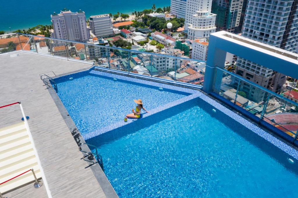 a person sitting in a swimming pool on top of a building at DQua Hotel in Nha Trang