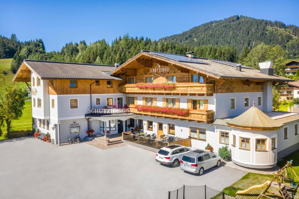 a large house with cars parked in a parking lot at Gasthof Schützenhof in Flachau