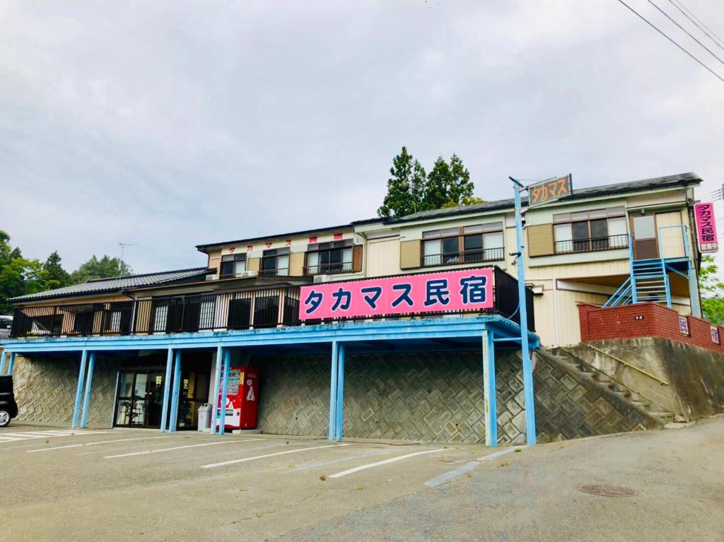 un bâtiment avec un panneau à l'avant dans l'établissement タカマス民宿, à Ōtsuchi