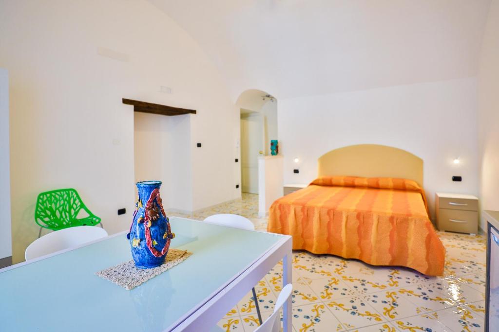 1 dormitorio con 1 cama y un jarrón sobre una mesa en Della Monica Rooms, en Vietri