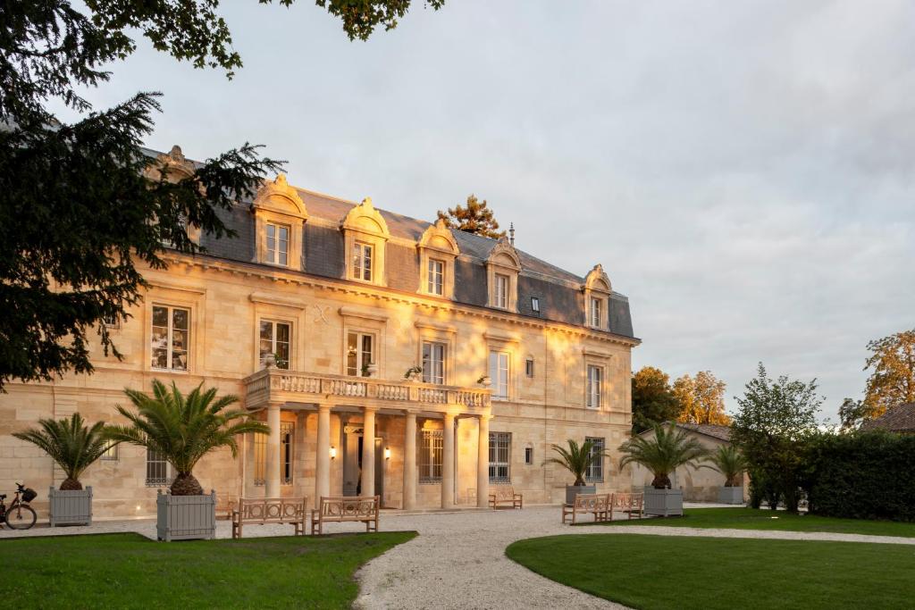 un gran edificio con bancos delante en La Maison d'Estournel, en Saint-Estèphe