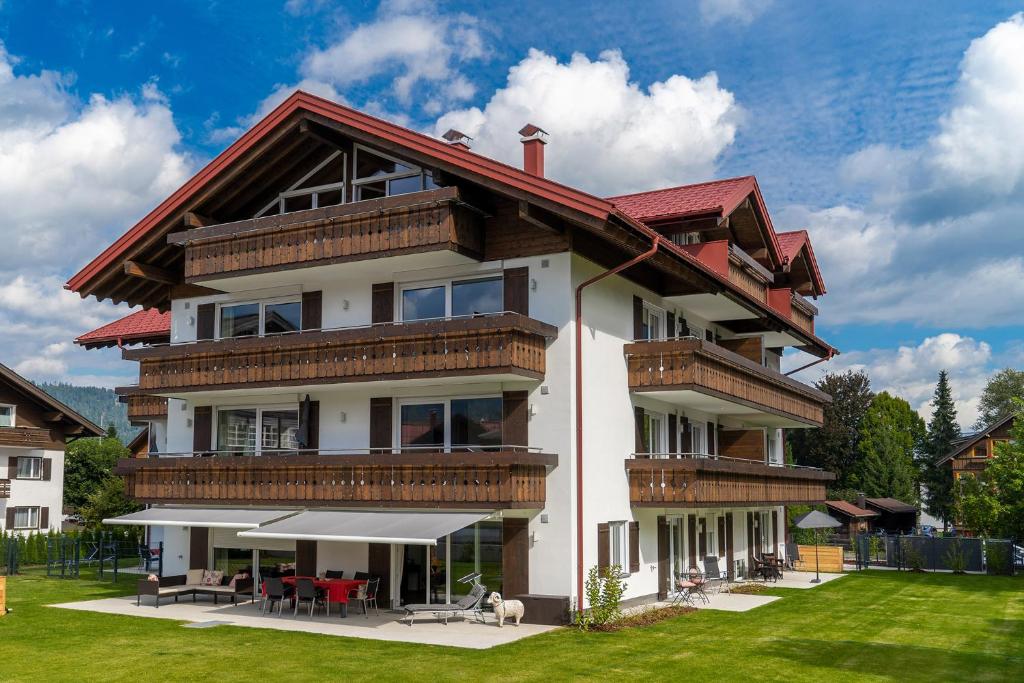 ein großes Haus mit rotem Dach in der Unterkunft Haus Alpenherz in Oberstdorf