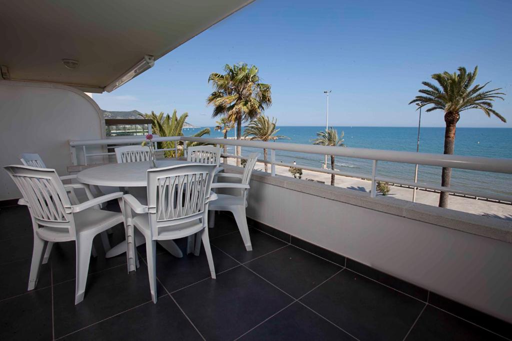 balcón con mesa, sillas y vistas al océano en Apartamentos Sunway Talaia, en Sitges
