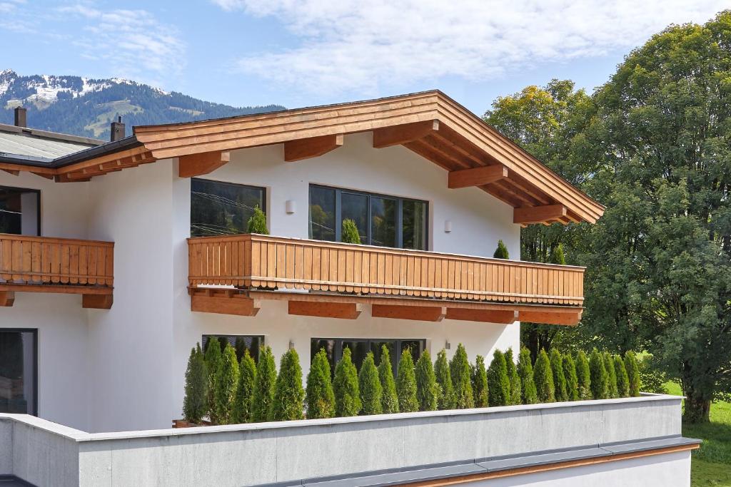 a house with a balcony and a row of trees at Kitz Mountain Living in Aurach bei Kitzbuhel