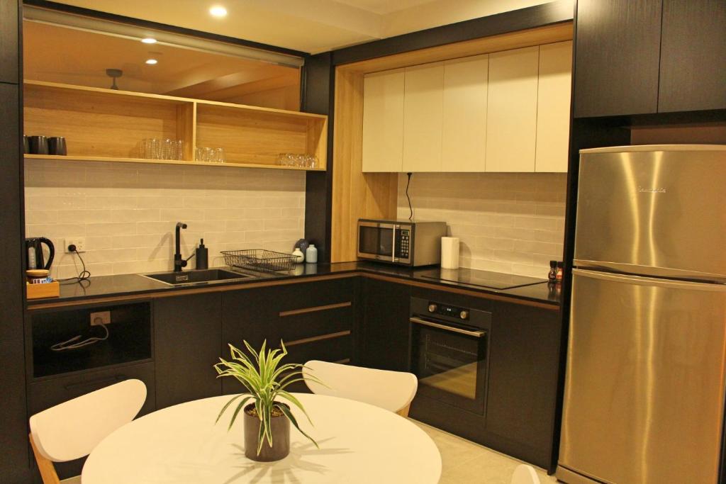 una cucina con tavolo e frigorifero in acciaio inossidabile di Stylish, Modern, Cute as a Button - Braddon CBD a Canberra