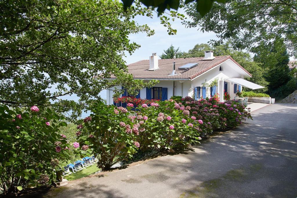 a white house with pink flowers in front of it at ATERIAN LAZKANO ENEA. in Getaria