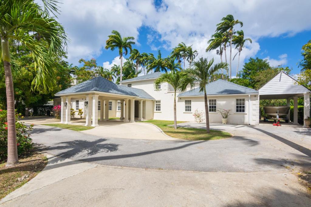 a white house with palm trees in the driveway at Royal Palms, St James in Saint James