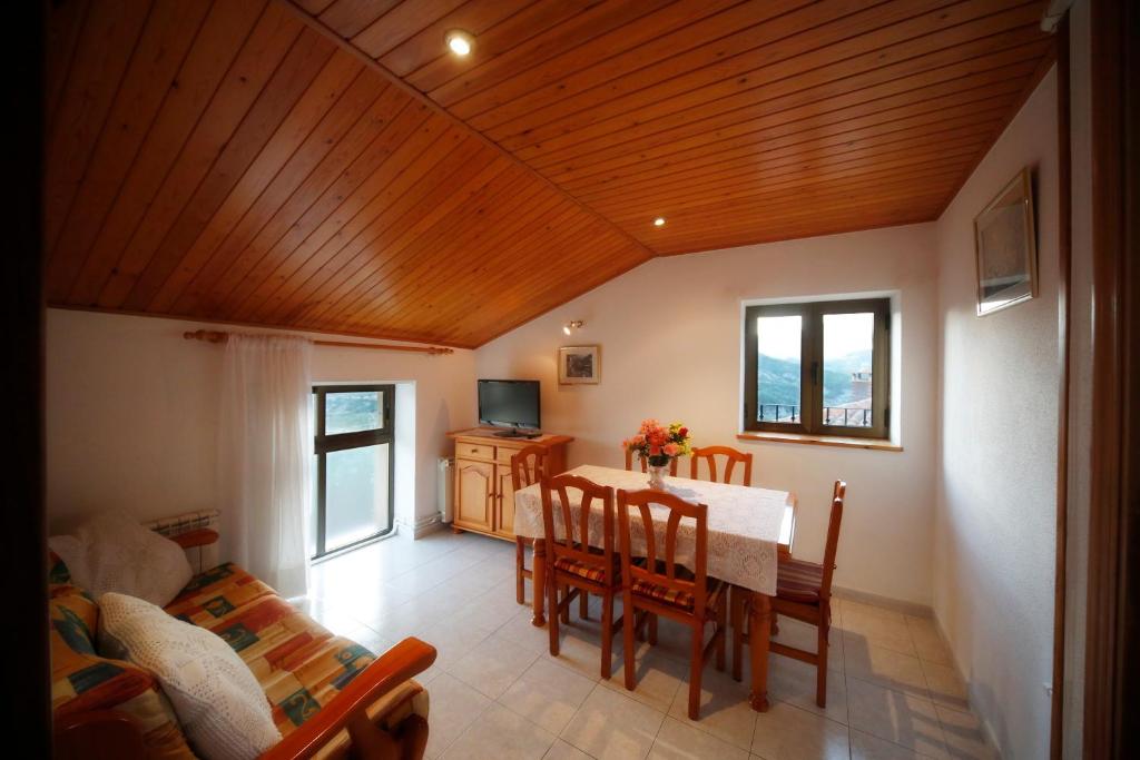 a dining room with a table and chairs and a couch at Casa Sallan Laspuña Ordesa Pirineo in Laspuña