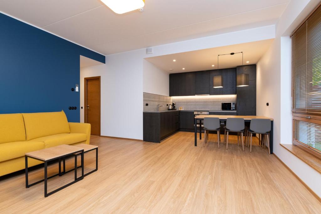a living room with a yellow couch and a kitchen at Self-check-in 2 bedroom apartment with a terrace and free parking in Tallinn