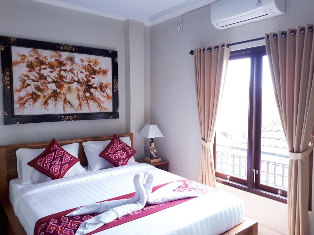 - une chambre avec un lit et une grande fenêtre dans l'établissement Sarwi homestay, à Ubud