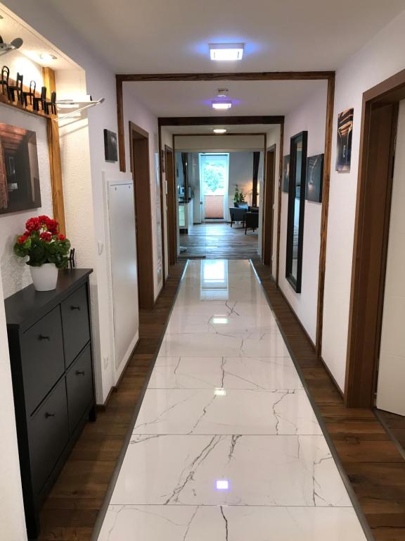 a hallway with a white tile floor in a house at Wieko Ferienwohnungen - Luxus Pur im Prinz von Preußen in Bad Elster