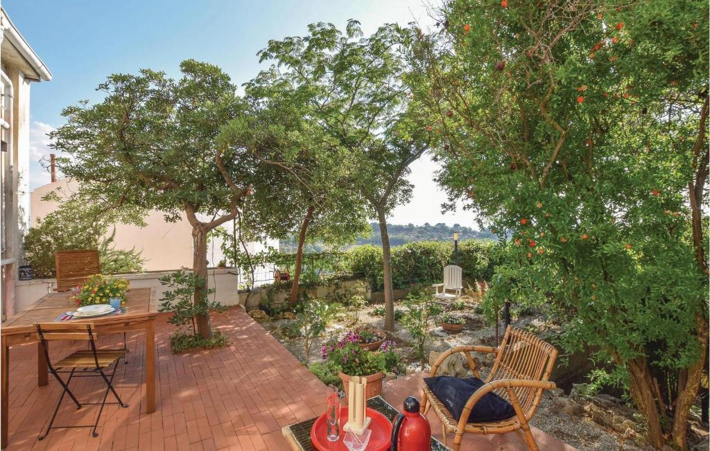 un patio con tavolo, sedie e alberi di Nice Apartment In Ferrandina With Kitchen a Ferrandina