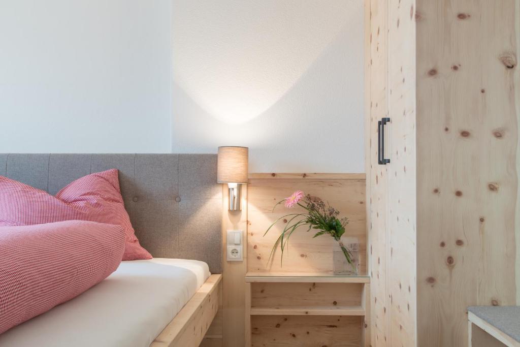 een slaapkamer met een bed met een houten muur bij Tschott Hof in Villandro