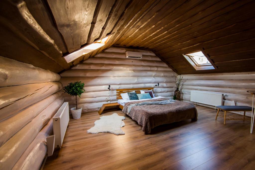 1 dormitorio con 1 cama en una cabaña de madera en Банний клуб Столичний, en Vita-Pochtovaya
