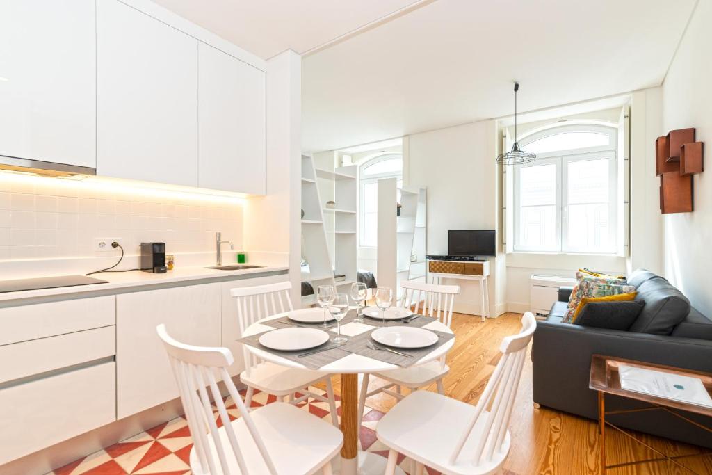 a kitchen and a living room with a table and chairs at Modern Apartment in the Historical Center in Lisbon
